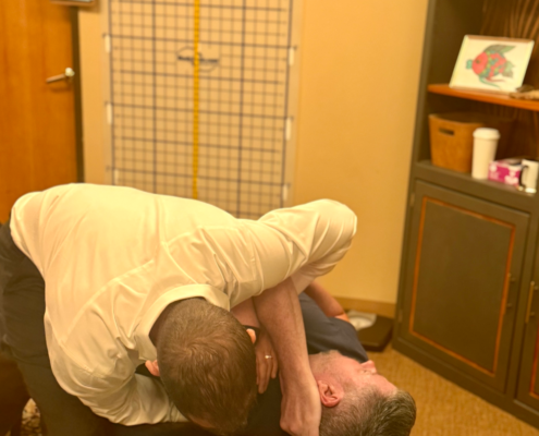 Dr. Joe Heinecke, DC performing an adjustment on a male patient.
