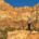 Hiker standing among red rock cliffs representing an active lifestyle and weather-related stiffness