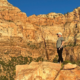 Hiker standing among red rock cliffs representing an active lifestyle and weather-related stiffness